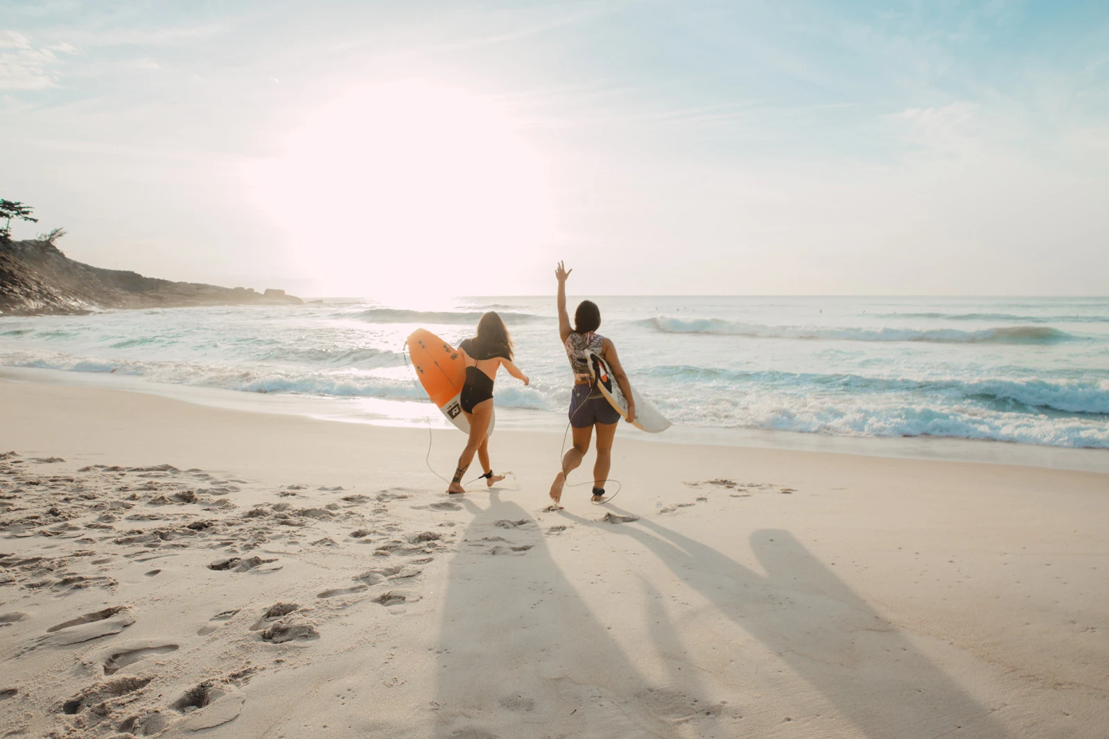 girls on beach with surfboards